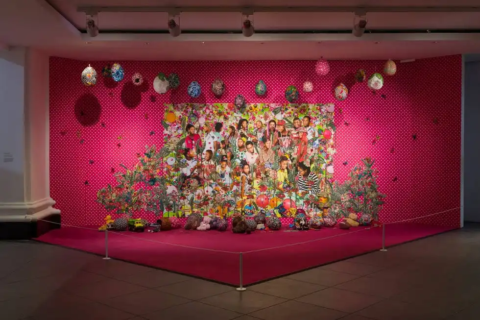 colorful artistic installation with a bright pink backdrop and various objects