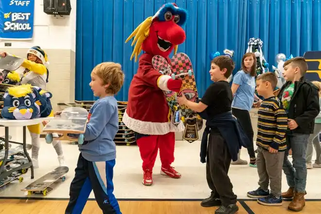 Indiana Fever mascot Freddy Fever gives out skateboards during the Pacers Sports & Entertainment 15th annual Big Toy Giveaway at Tekoppel Elementary School in Evansville, Ind., Thursday, Dec. 5, 2024.