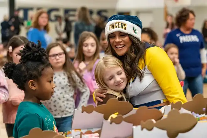 Pacemate Brooke gives a hug during the Pacers Sports & Entertainment 15th annual Big Toy Giveaway at Tekoppel Elementary School in Evansville, Ind., Thursday, Dec. 5, 2024.