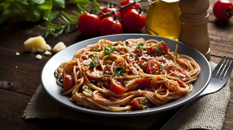 a plate of pasta with tomato sauce and parsley