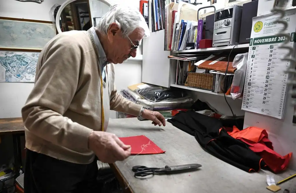 Raniero Mancinelli works on a cardinal’s cassock in his shop in Borgo Pio. Photo: AFP