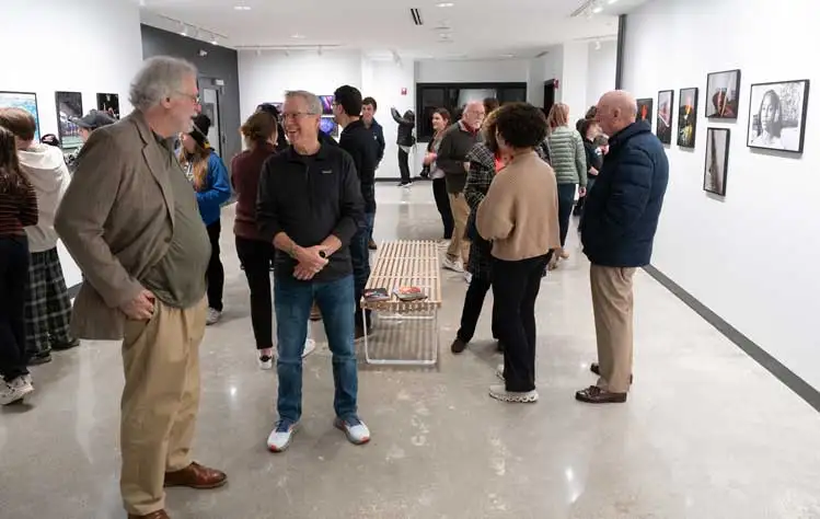 Dean Eric Rothenbuhler talks to patrons at the photo show