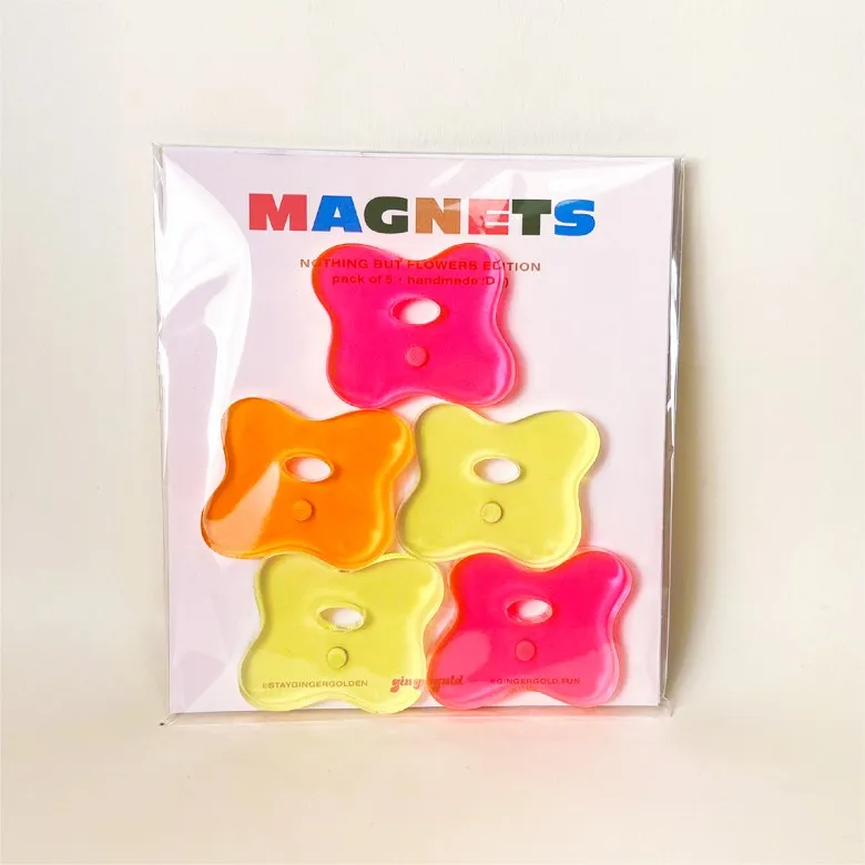 A color photo of a set of five neon-colored magnets shaped like flowers.