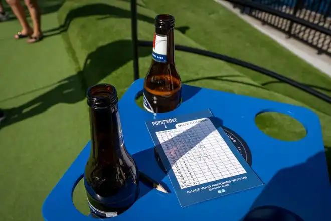 A scorecard and beers for patrons playing golf at PopStroke on December 20, 2024, in West Palm Beach, Florida. Tiger Woods, Greg Bartoliand TaylorMade Golf Company are the owners.