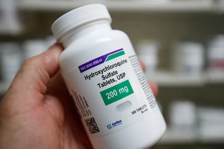 Close up view of a technician holding a bottle of Hydroxychloroquine at a pharmacy in Utah.