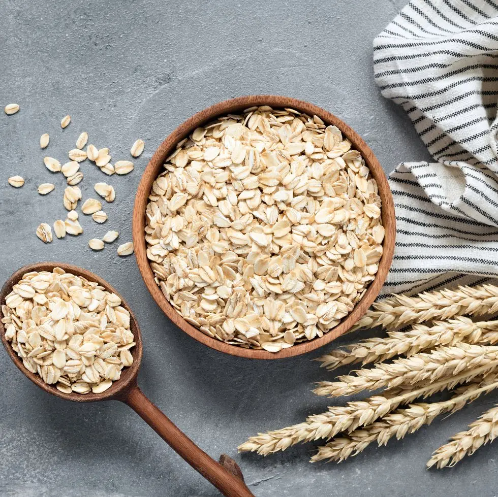 oats, rolled oats or oat flakes in wooden bowl