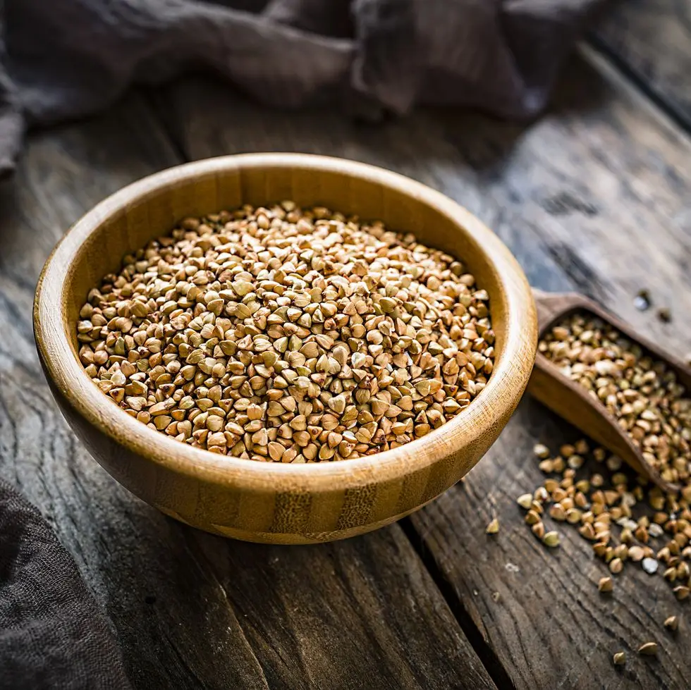 dietary fiber wholegrain buckwheat in a wooden bowl on rustic kitchen table