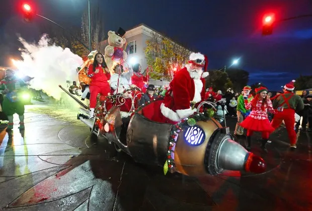 Thomas Bilbo, dressed as Santa, shoots smoke out of the back of his sleigh as he leads the Grand Marshals - the Tonga Twin Sisters - into Vallejo's Mad Hatter Holiday Festival and Parade in 2023. (Chris Riley - Times-Herald)