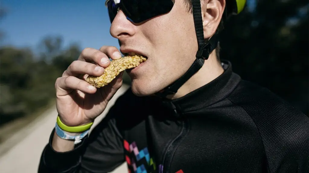 close-up of cyclist eating protein bar