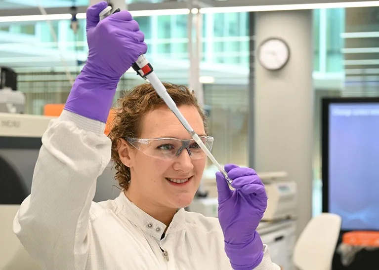 Annie Woolven is seen holding a pipette in the lab