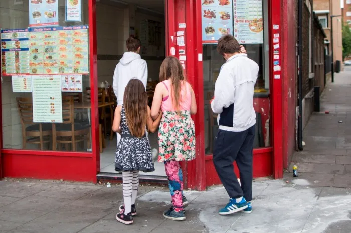 Children enter a fast food shop in east London