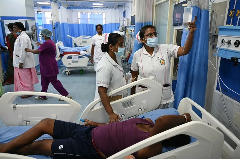 Nurses provide medical care to a patient in a ward for heatstroke patients at a government hospital in Chennai.