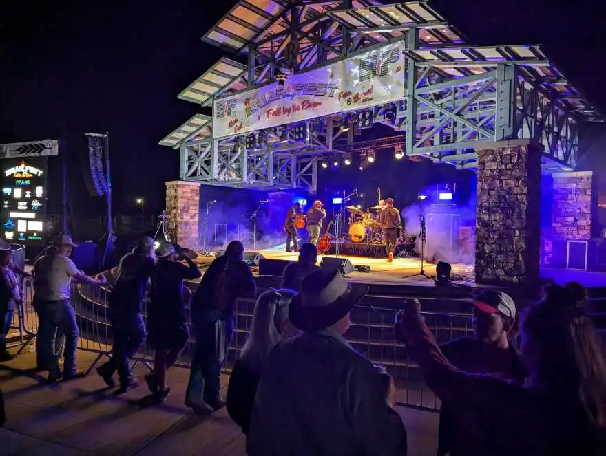 People stand in front of an outdoor stage at Briarfest while a band plays.