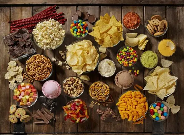 Crisps, chocolate, pretzels, ice cream and sweets on a table