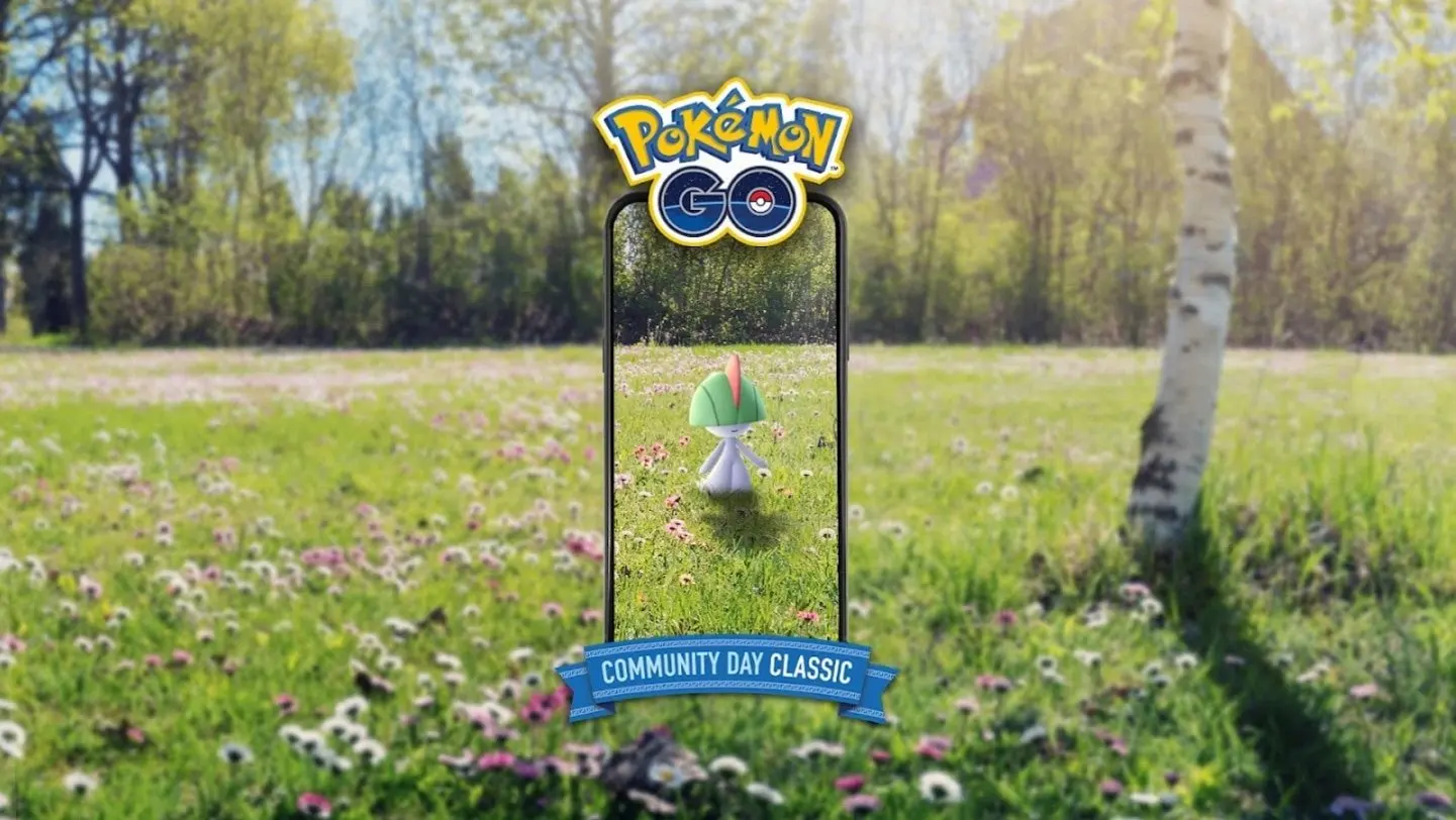 A field of small flowers and long grass with a silver birch tree on the right is shown. It is a sunny spring day and there are trees out of focus in the background. In the centre the outline of a mobile phone has a Ralts in the centre. The top of the phone reads 'Pokémon GO' and the bottom reads 'Community Day Classic'