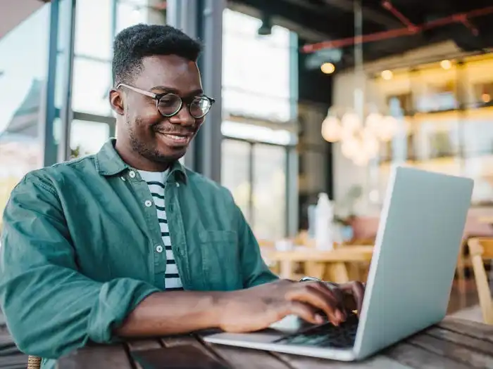 a man sitting on his computer in a cafe working