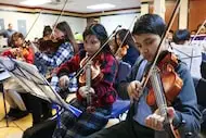 Leah Moreno and Dahir Elizarraras rehearse the viola with the other members of the orchestra...