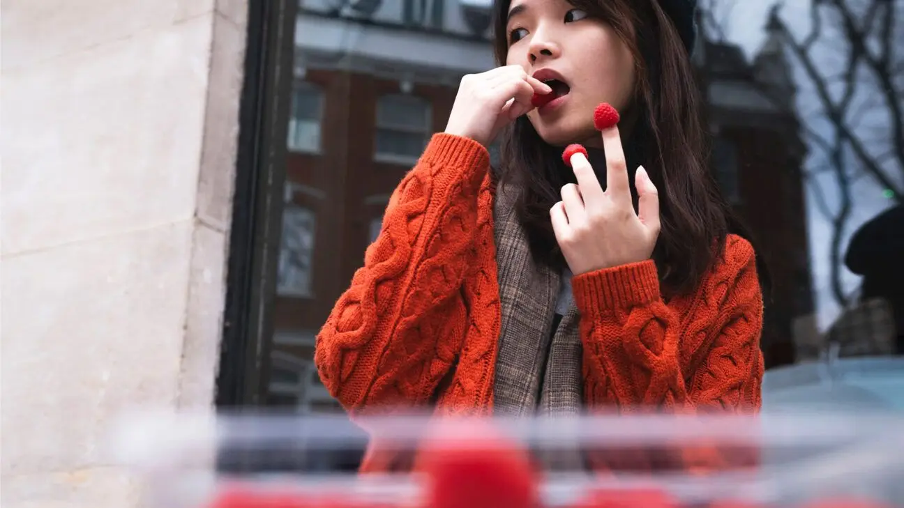 Female eating berries in red sweater