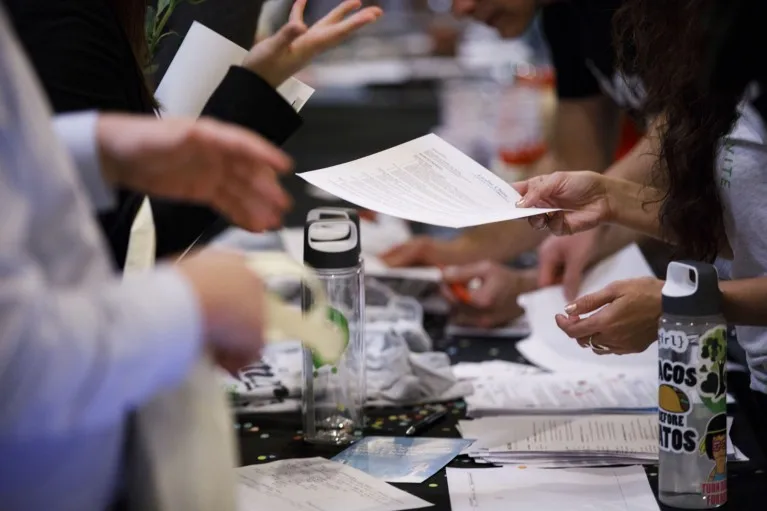 Close-up of a person handing over their CV during a career fair