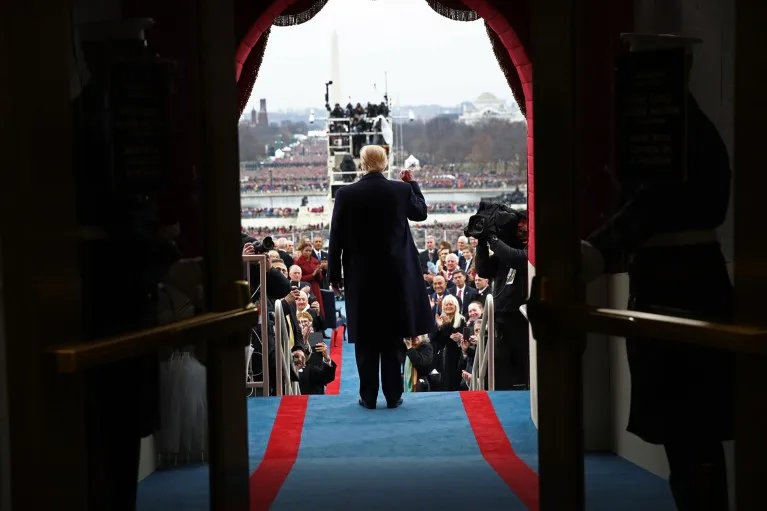 Rear-view of Donald Trump lifting his right fist on the West Front of the US Capitol in front of crowds of people