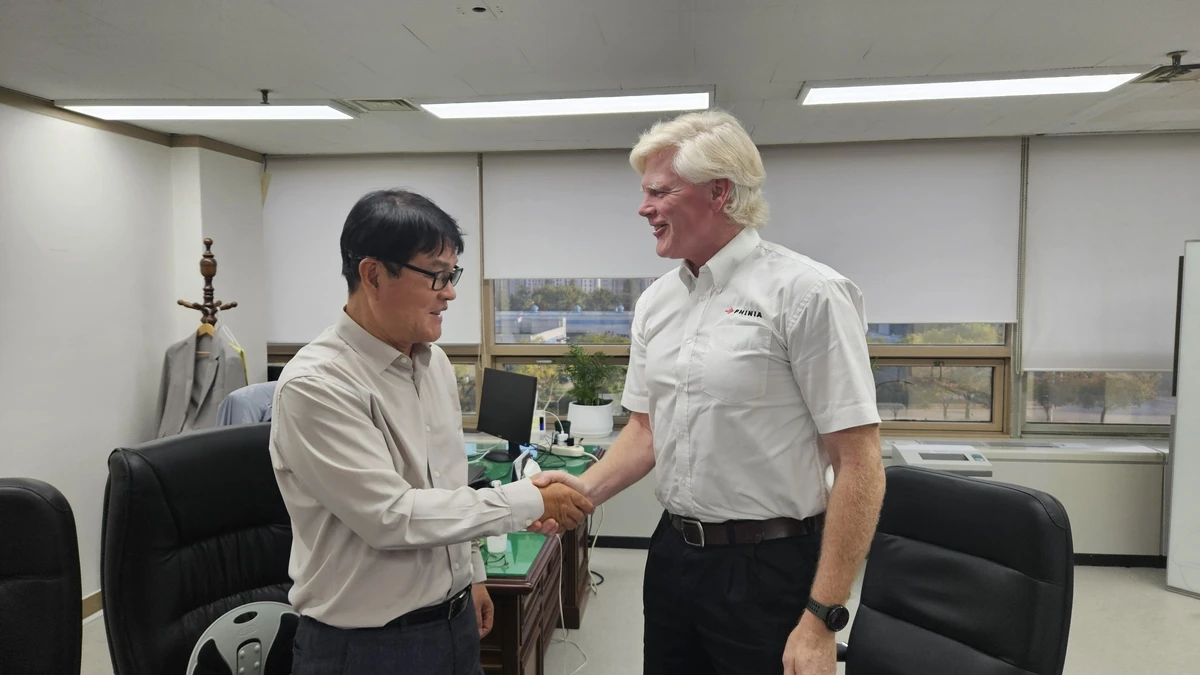 This photo provided by KG Mobility shows Kwon Yong-il (L), head of research at KG Mobility, and Todd Anderson, vice president and chief technical officer at Phinia Delphi France, shaking hands during a signing ceremony for the companies' hydrogen engine joint development agreement held at the South Korean automaker's research center in Pyeongtaek, south of Seoul, on Jan. 15, 2025. (PHOTO NOT FOR SALE) (Yonhap)