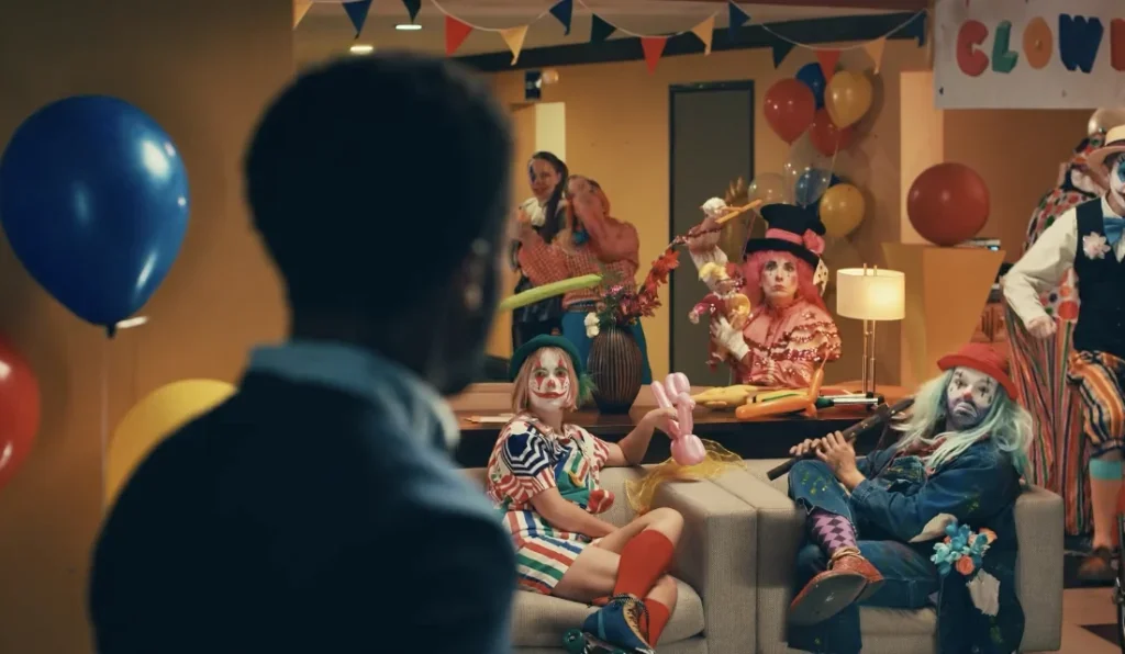 man looks surprised at a living room full of clowns