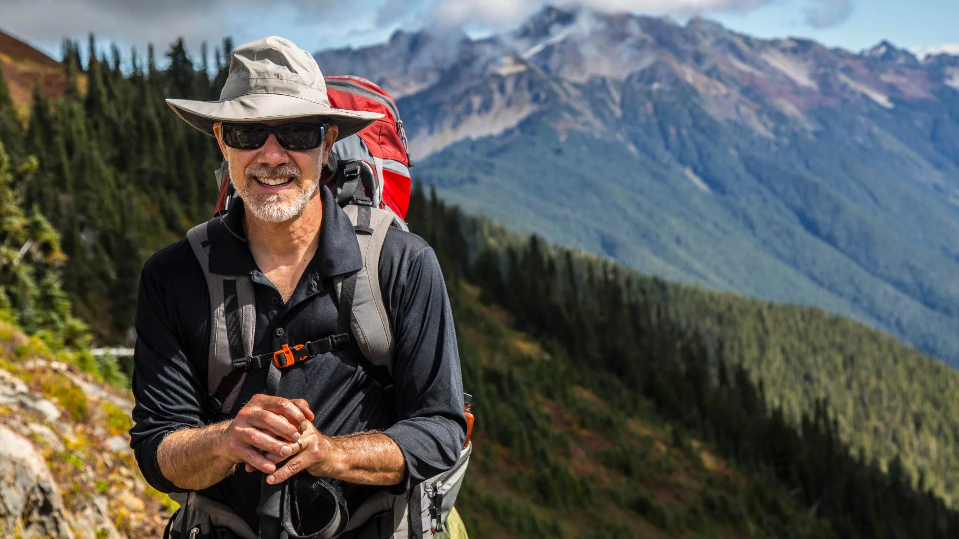 Older man hiking up a mountain