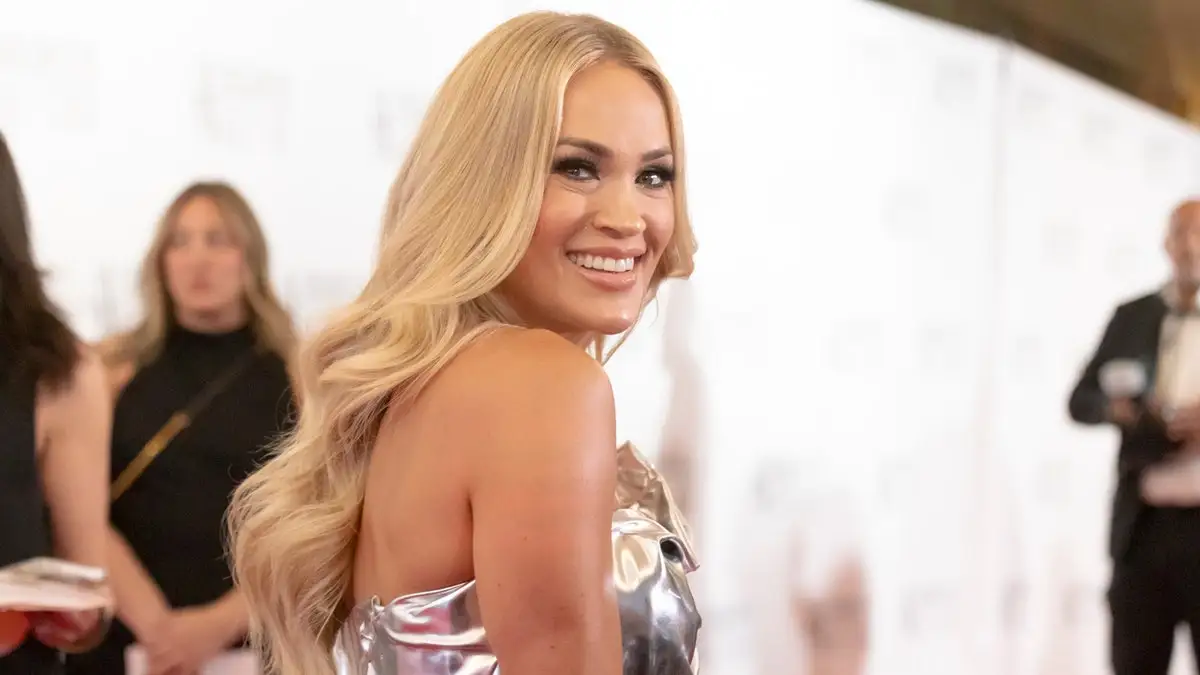 Carrie Underwood in a silver dress looks over her shoulder at the 2024 Songwriters Hall of Fame Induction and Awards Gala