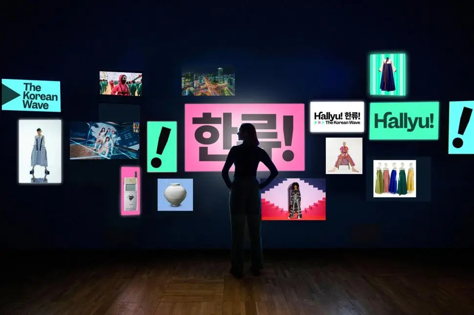 A visitor in front of a series of screens with korean signs