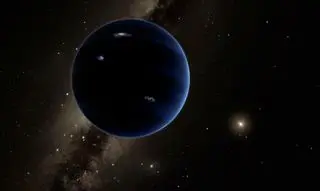 a dark blue planet seen against a starry background