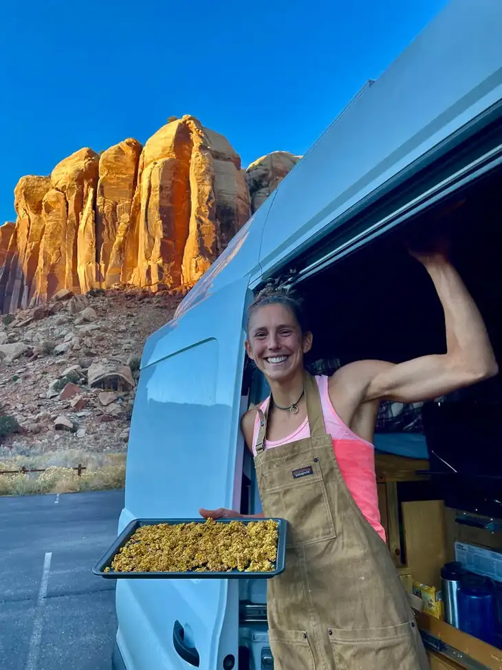 A climber in a van with a tray of granola