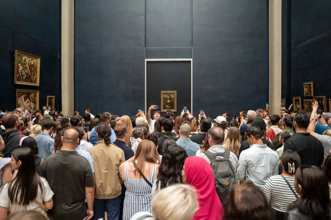 Crowd of tourists with their phones in hand, taking photos of Leonardo da Vinci's Mona Lisa inside the Louvre Museum in Paris, France on June 7, 2024.