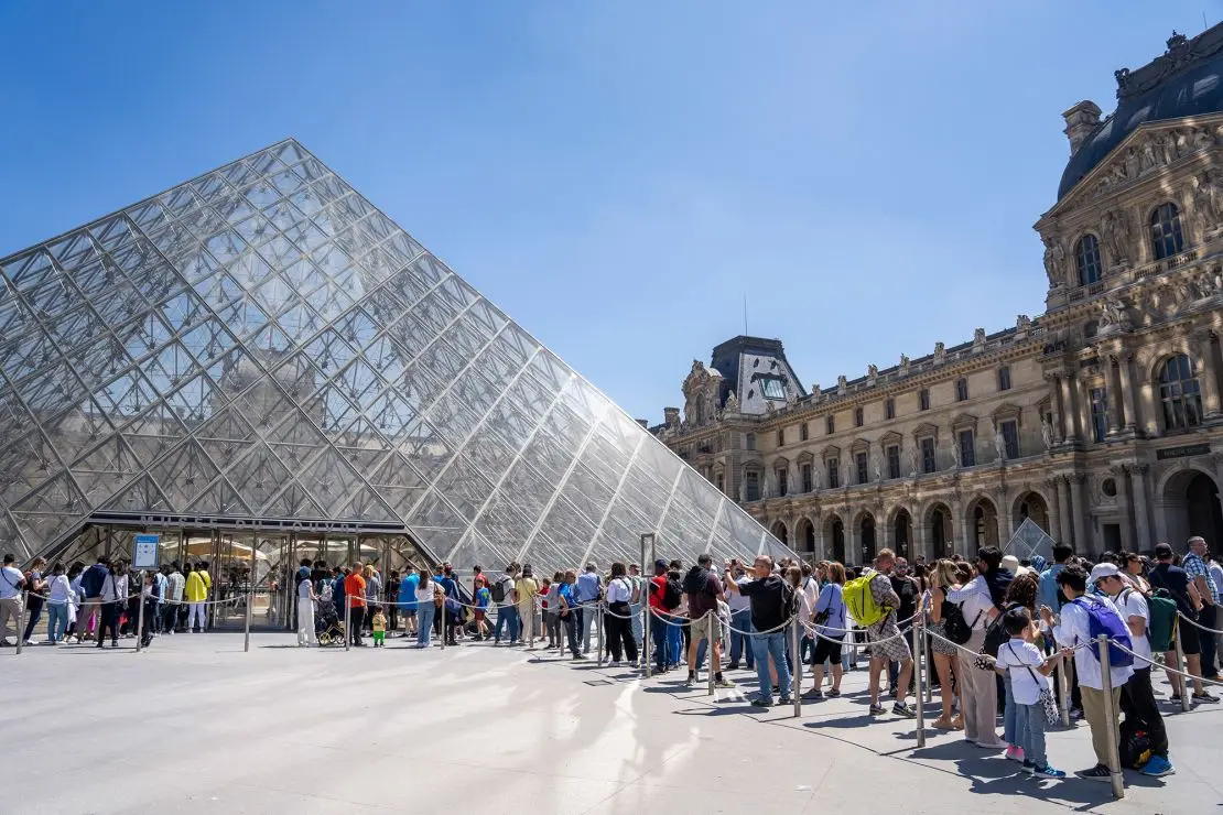 Tourists queuing to enter the Louvre museum and pyramid in Paris, France on June 7, 2024.