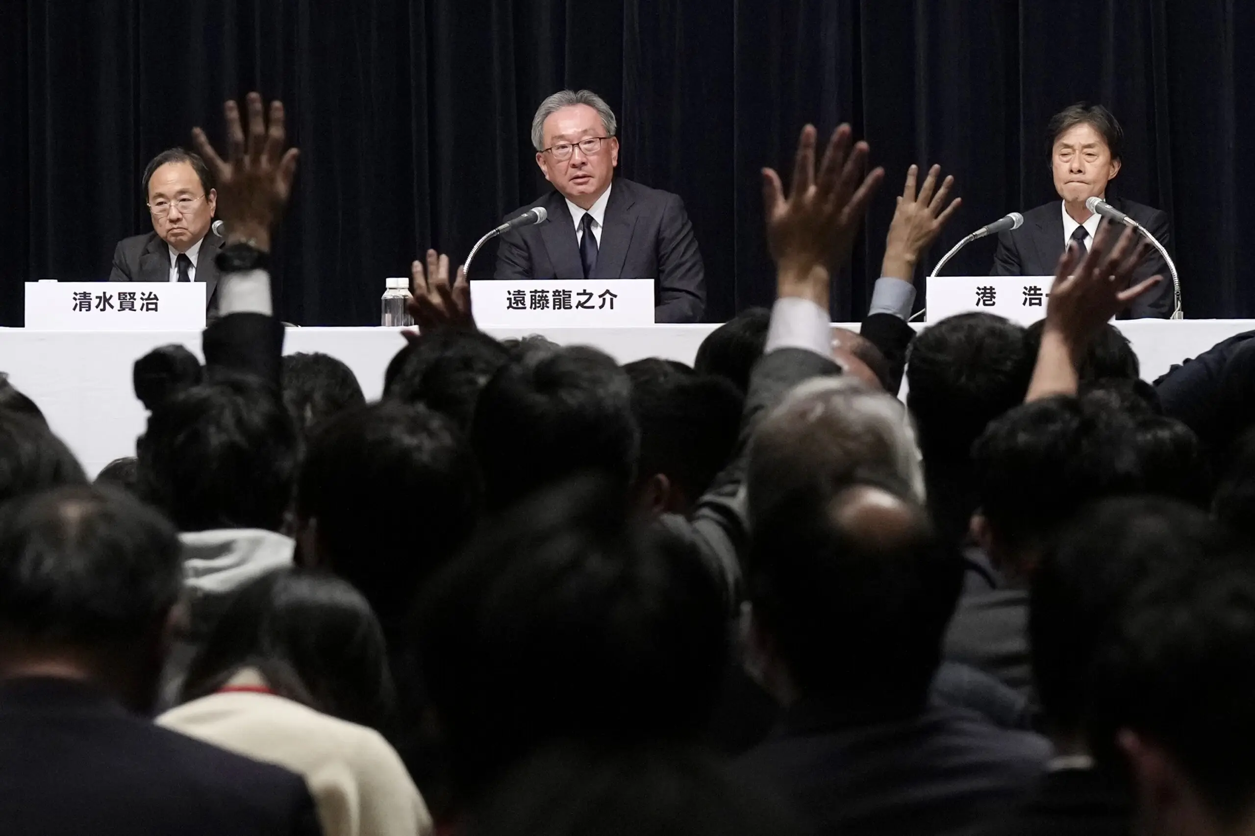 Three Fuji Television Network executives at a press conference.