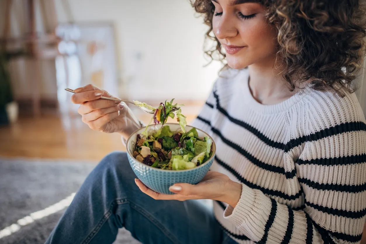 VegNews.WomanEating.Getty