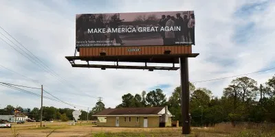 A billboard with text reading 'MAKE AMERICA GREAT AGAIN' laid over a black and white photograph of police confronting Black protestors.