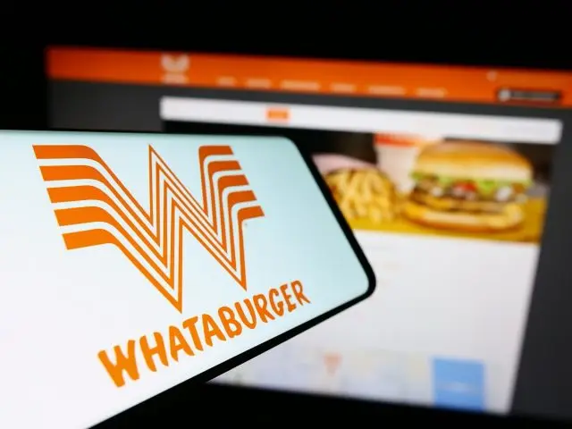 Stuttgart, Germany - 12-31-2023: Smartphone with logo of American fast food company Whataburger Restaurants LLC in front of business website. Focus on center of phone display. Unmodified photo.