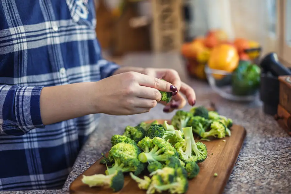 Young woman chopping vegetables for healthy vegetarian meal