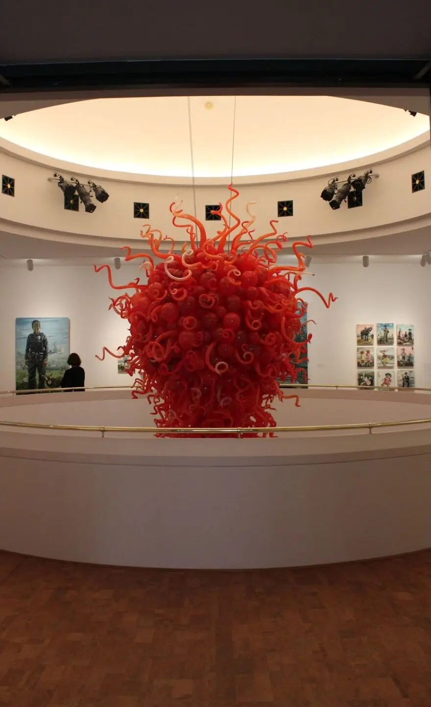 Upper floor gallery is built around fire engine red Dale Chihuly chandelier