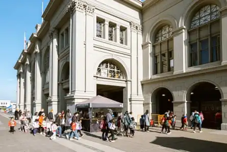 A group of students accompanied by chaperones walk to a farmers market