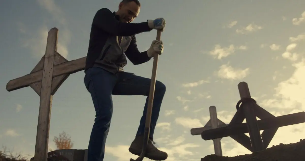 A man digs a grave in a cemetery