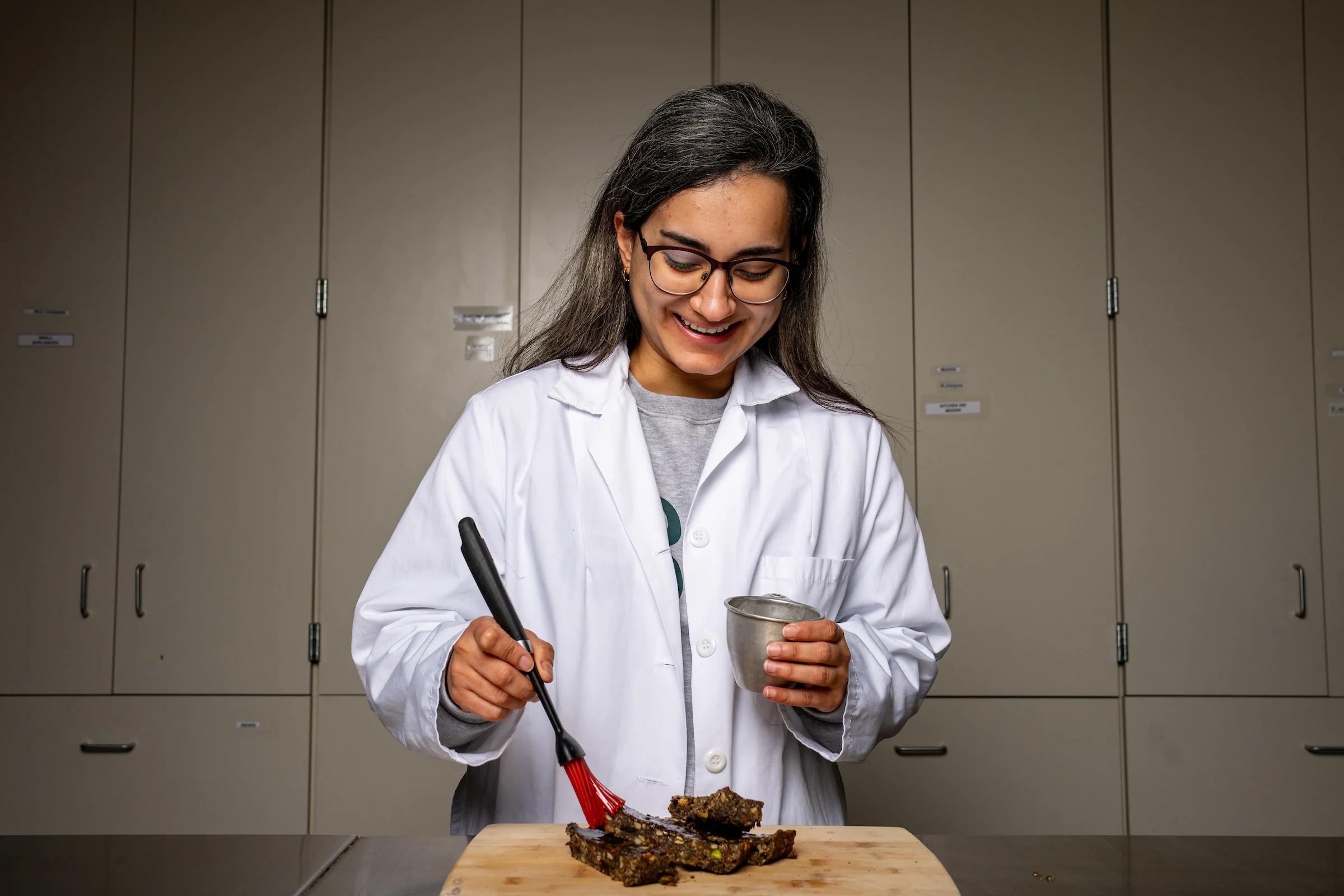 Graduate student Armaghan Amaniqour putting a glaze on Fermented/bioprocessed agri-food waste protein bars.