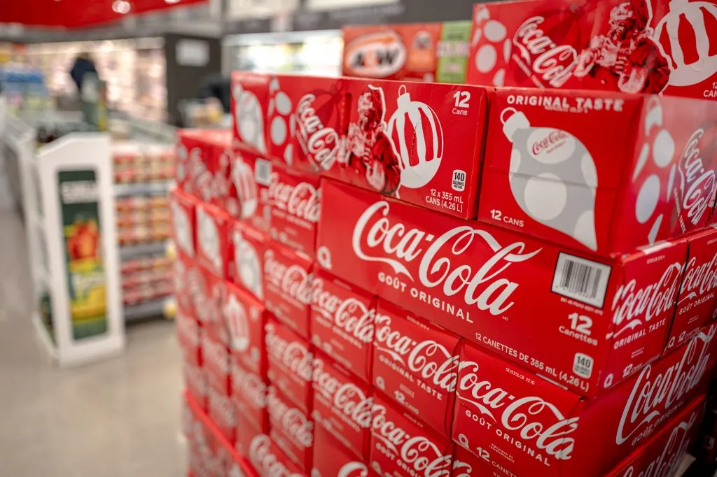 American soda brand displayed in a grocery store in Montreal, Canada, with news about US President Donald Trump's tariff decisions in 2025