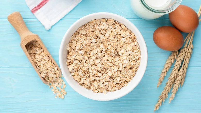 bowl of oats by two whole eggs and milk pitcher