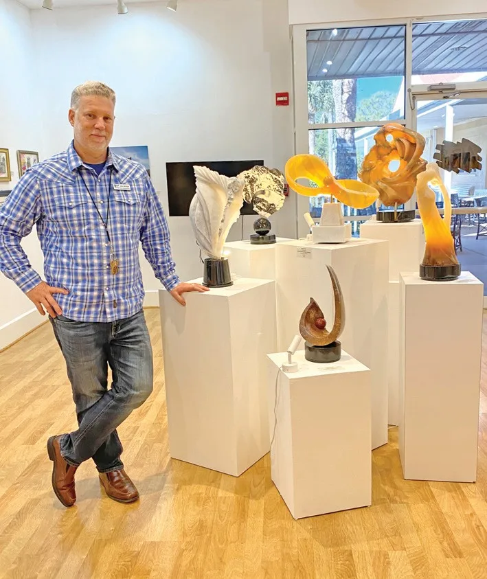 Jon Artigo, Arts Bonita education director, stands next to an array of sculptures created by Arts Bonita faculty.