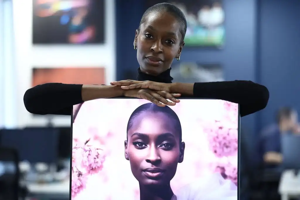 Alexsandrah Gondora poses for a photograph with her on-screen AI twin “Alex”, created by digital modelling agency The Diigitals. Photo: AFP