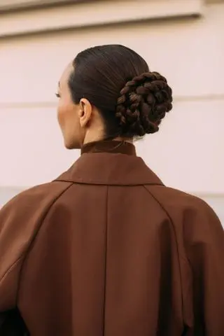 woman at milan fashion week with a braided bun