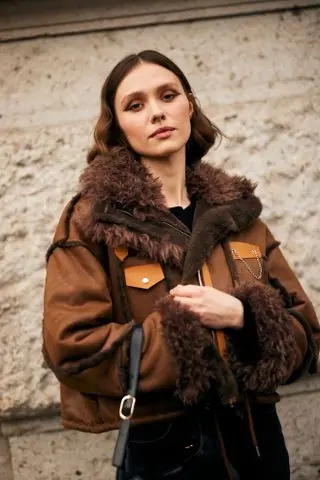 woman with burgundy eyeshadow and a shearling coat