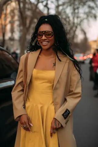 woman in a yellow dress and trench coat