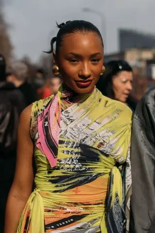 woman in a green and pink dress and tight bun